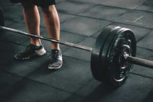 Personal trainer geeft begeleiding bij trainingsschema en motiveert cliënt tijdens het sporten in de sportschool