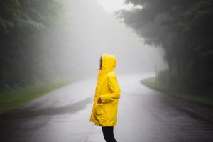 Home Vrouw in regenjas die gezond blijft in de regen met juiste beschermende kleding