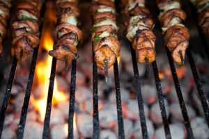 Home Familie geniet van geslaagde barbecue buiten, lekkerste BBQ met vlees en groenten op de grill