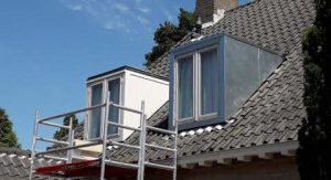 Home Professioneel vakman voert montage van zinken regenpijp en dakgoot uit met precisie en vakkundigheid